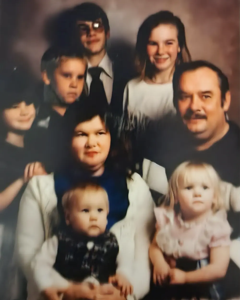 A 1992 family portrait of the Capino–Lonas household, with Joyce and Richard seated, surrounded by their six children, including Susan.