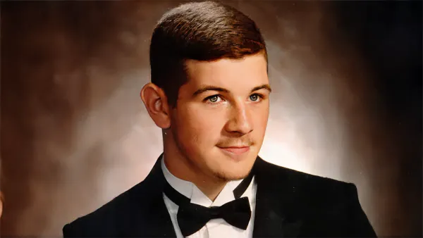 A portrait of Eric Grant Cheeks in a tuxedo and bow tie, set against a blurred brown background with a composed expression.